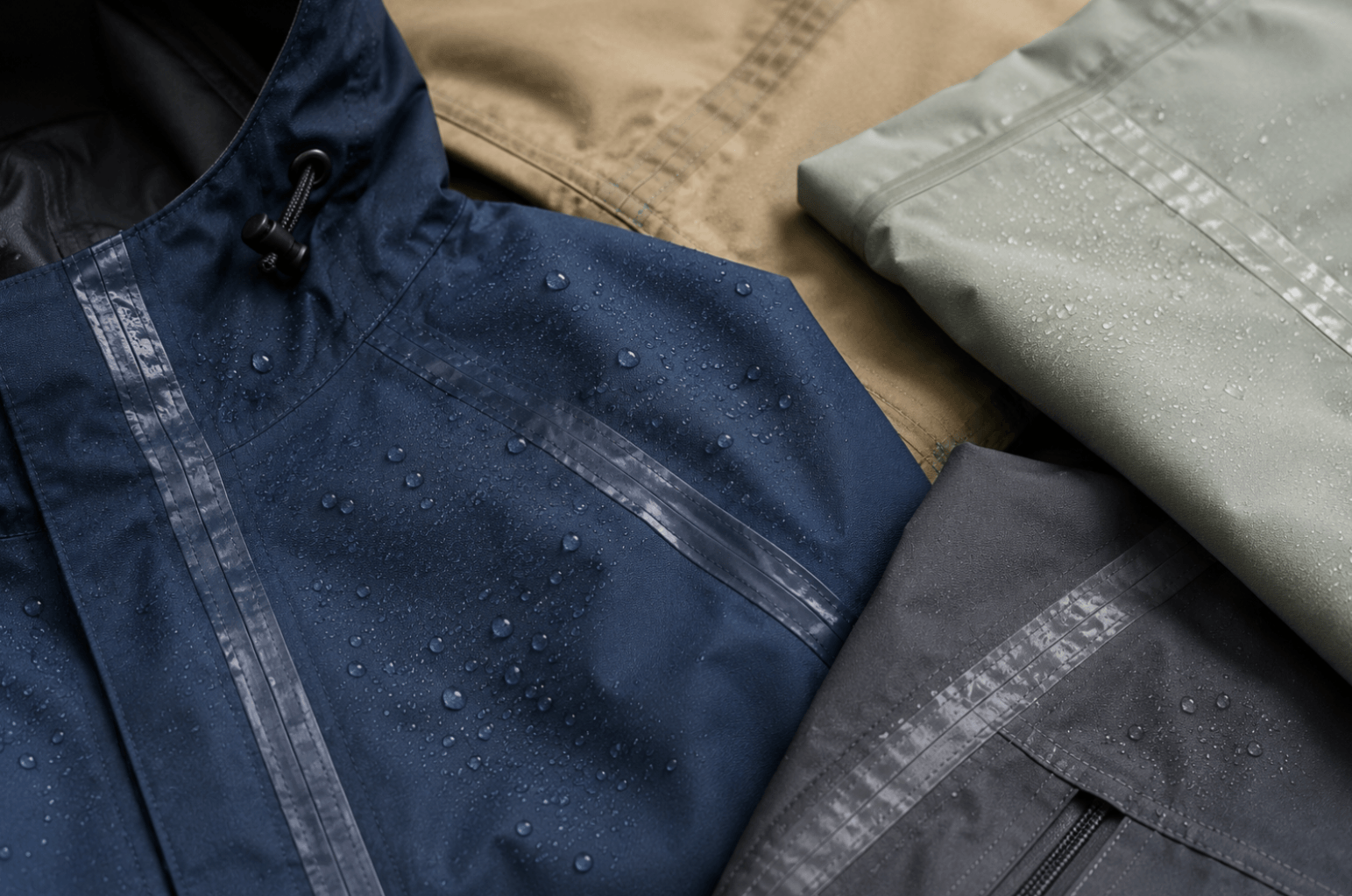 Detailed view of a waterproof jacket seam with seam sealing tape and water droplets highlighting a fully sealed waterproof construction.